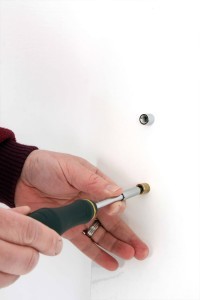 2. Use a drill and drill the holes where you marked the wall with the pencil, it is recommended you use drywall anchors to help secure your display. Attach the spacer to the wall using appropriate screws. Use the acrylic spacers supplied on the large attachment, place these in between the attachment and wall, depending on your wall you may need to use 2 or 4 to ensure back panel sits straight